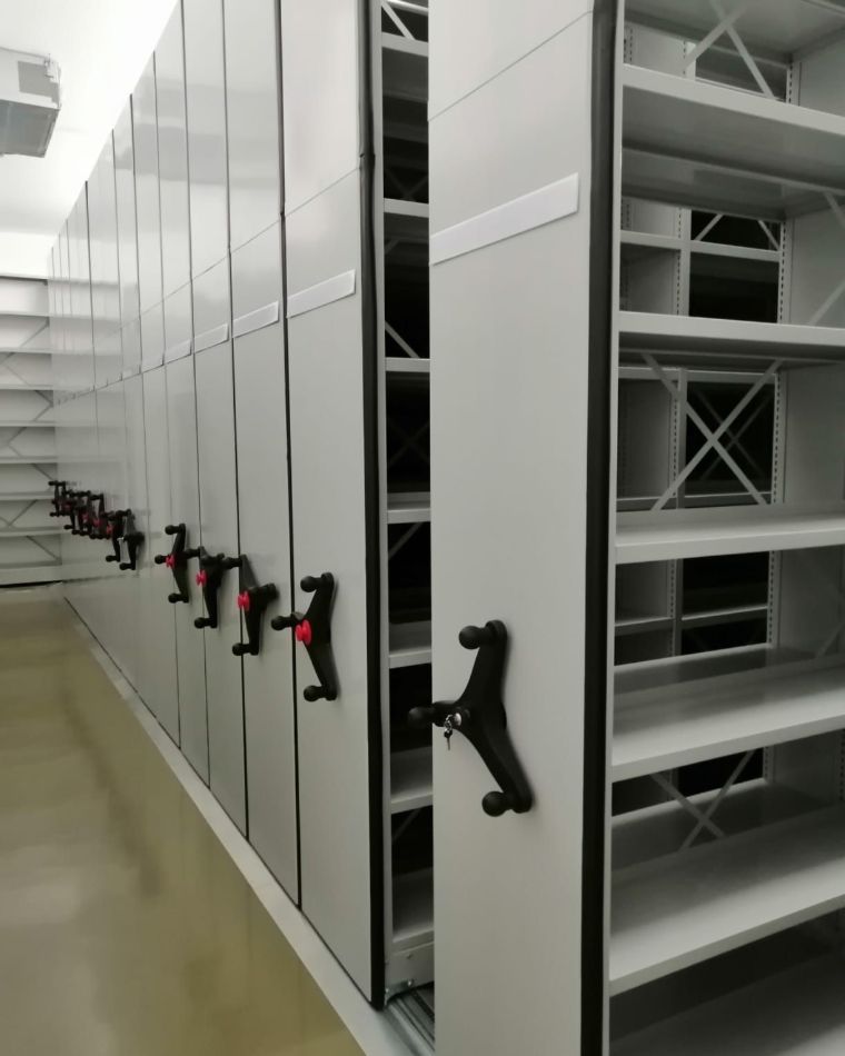 Estantes compactas móveis com manípulos num arquivo